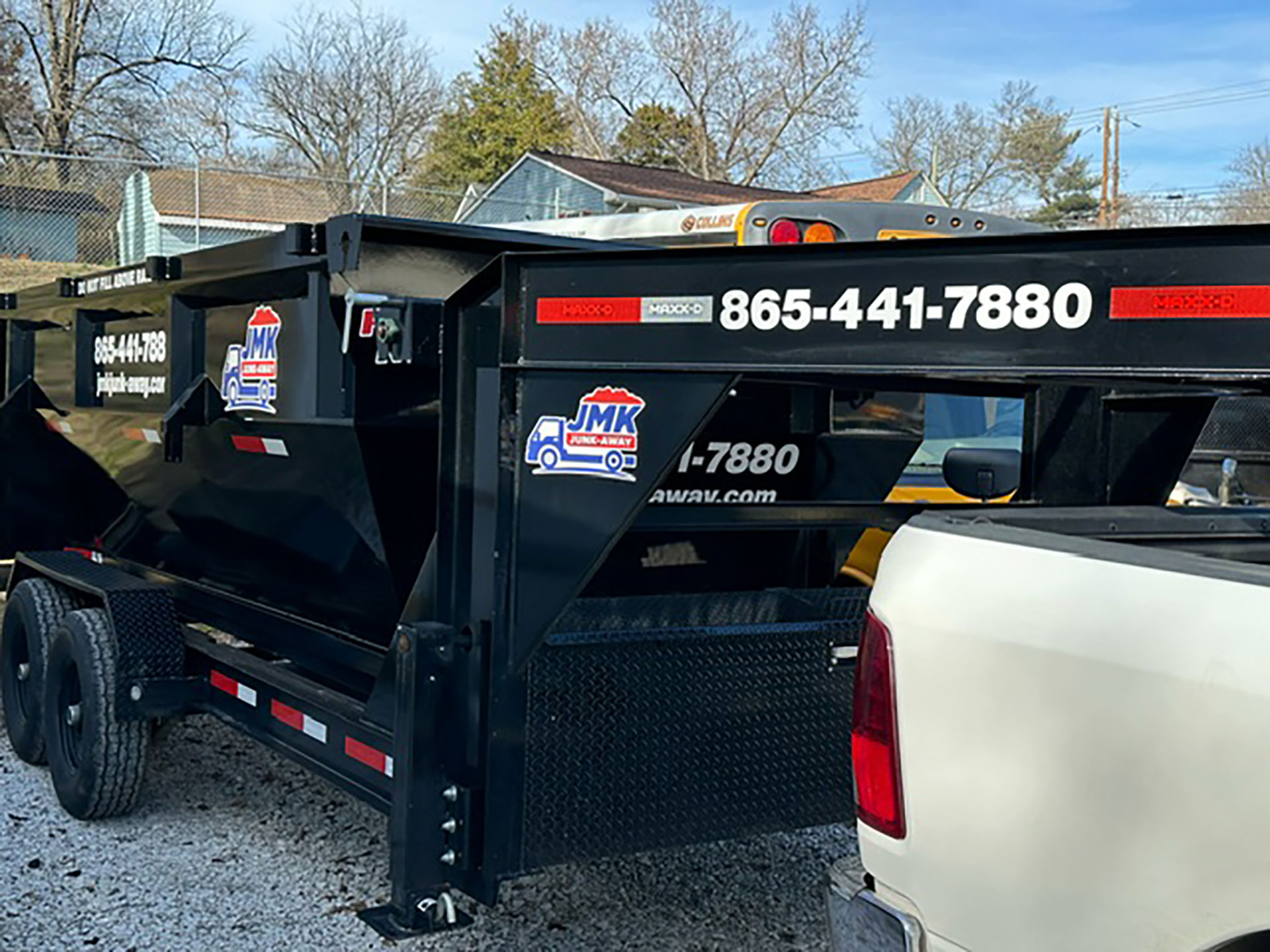 JMK-branded roll-off dumpsters ready for transport